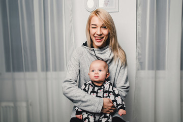 mother and little baby show different emotions in the camera