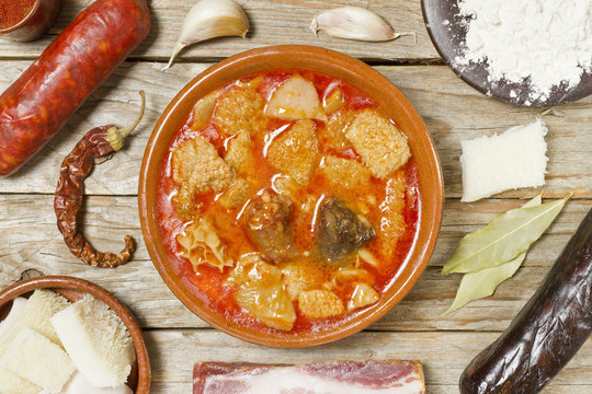 Spanish callos and ingredients on a white blackground