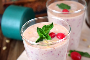 Protein cocktail for healthy nutrition decorated with cranberries, mint and pine kernel nuts in a glass