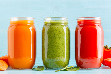 Fototapeta na wymiar Orange/green/red colored smoothies / juice in a jar