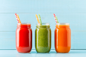 Orange/green/red colored smoothies / juice in a jar