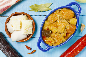 Spanish callos and ingredients on a white blackground