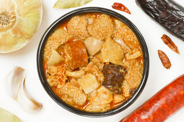Spanish callos and ingredients on a white blackground