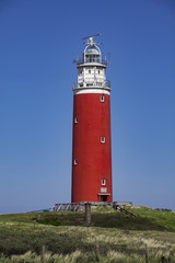 Fototapeta na wymiar Red lighthouse tower in the beach