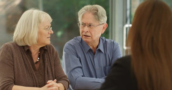 4K Senior couple in a meeting with financial adviser reacting to bad news. Slow motion