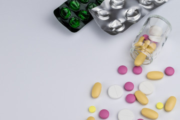 Blister and glass bottle with pills on white background