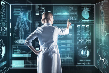 Medical innovation. Calm smart enthusiastic doctor using amazing futuristic technologies while working at the new important research
