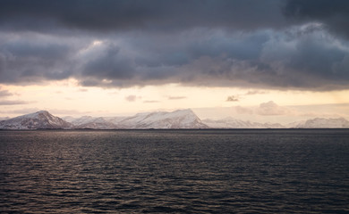 Naklejka na ściany i meble Beautiful snow coverd landscape on a boat to Lofoten