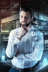 Looking interesting. Attentive experienced young programmer thoughtfully touching his beard and...
