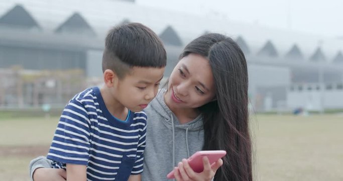 Mother talk to her son and use of smart phone together