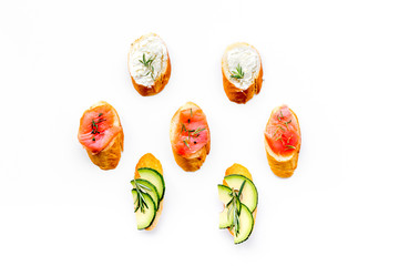 homemade sandwiches with french baguette, salmon, cheese and vegetable on white background top view mock-up