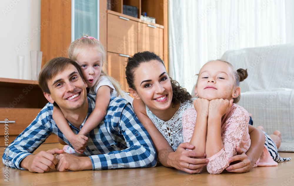 Wall mural family values: portrait of parents with little girls indoors