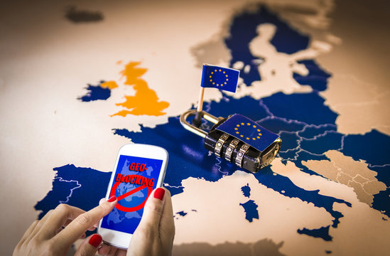 Female hands using a smartphone with geoblocking on screen and Padlock over EU map. European Union Digital single market and regulation against Geo-blocking and geographically-based restrictions
