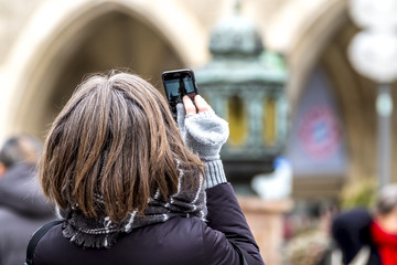 Lady photographing with smart phone the town hall in Munich city, Germany
