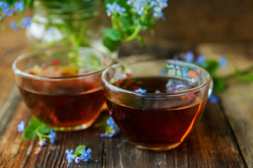 Marble cupcake and tea with flowers on a wooden background