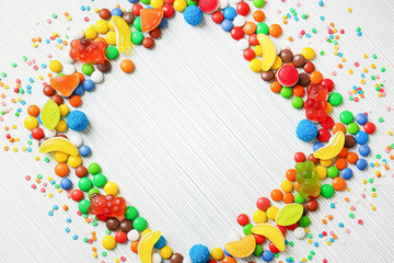 Frame of colorful candies on light background