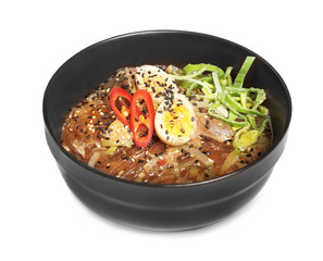 Delicious ramen soup with pieces of bonito in bowl on white background
