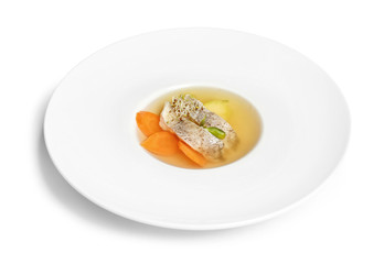 Delicious consomme soup with pieces of codfish in plate on white background