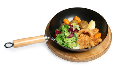 Frying pan with delicious fish fillets and vegetables on white background