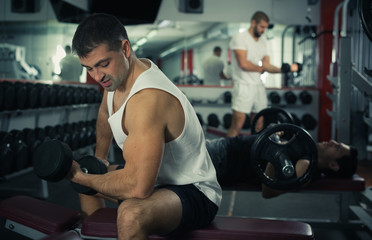 Man doing exercises with dumbbells at gym