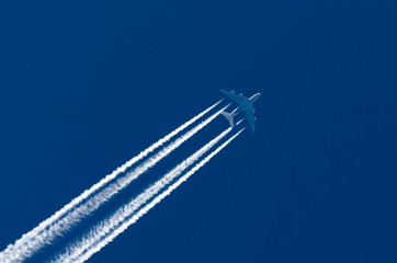 Huge airplane big four engines aviation airport contrail clouds.