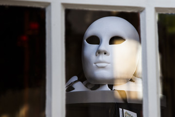 White mask behind a window in Aix en Provence France.