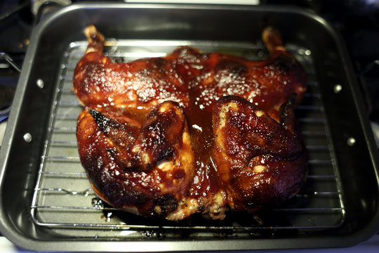 Baked BBQ Spatchcock chicken cooling on the stove.