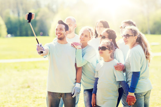 group of volunteers taking smartphone selfie