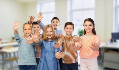 happy students waving hands at school