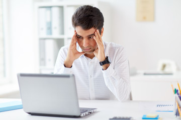 stressed businessman with laptop at office