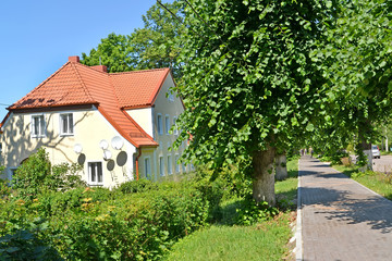 The house with a tile roof on Sovetskaya Street in the summer afternoon. Settlement Amber, Kaliningrad region