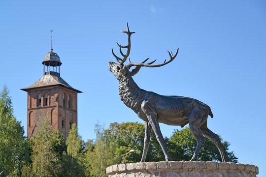  A sculpture of a deer and Saint Yakov's Lutheran church against the background of the sky.