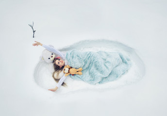 the spring has woken up, the woman lays in a snow covered with a blanket, soft fluffy and cozy...