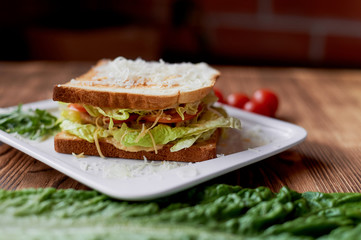 A delicious sandwich with salad and chicken. Sprinkled with cheese. A quick delicious Breakfast