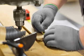carpenter with ruler measuring board at workshop