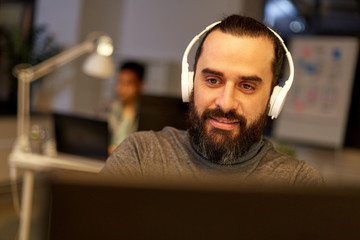 creative man with headphones working at office