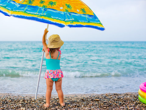 Child On Beach Under An Umbrella