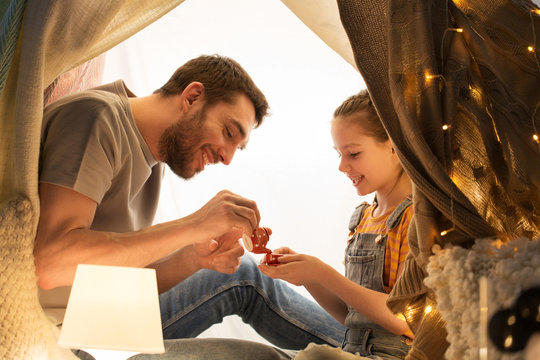 Family Playing Tea Party In Kids Tent At Home