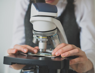 Little girl in science class using microscope. © M-Production