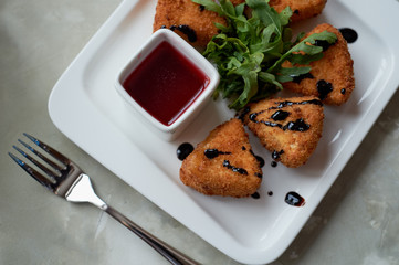 Camembert in batter, deep fried, with balsamic vinegar and arugula