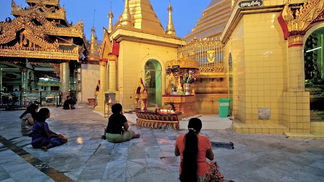 YANGON, MYANMAR - FEBRUARY 14, 2018: The Buddhist worshipers during the prayer in Sule Pagoda, on February 14 in Yangon.