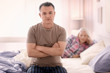 Senior couple with problem in relationship on bed