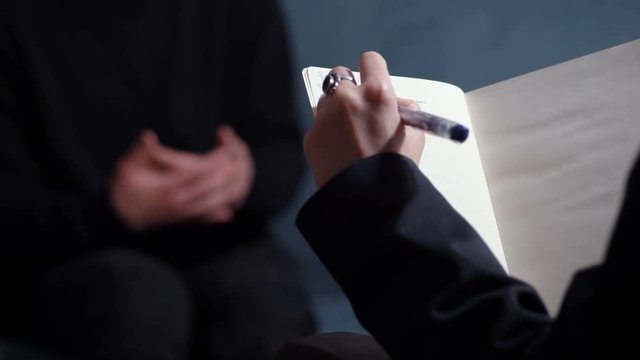 Therapy session: psycologist takes notes during session