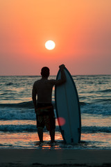 surfer walking on beach at sunset - 195552191