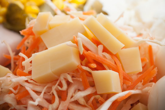 closeup of rapped carrots and cheese cubes in a plate
