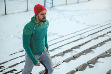 Sportsman walking up the stairs on snowy day