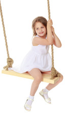 Little girl swinging on a swing