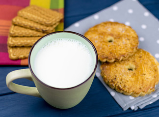 Large cup with milk and cookies in the background.