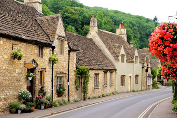 Fototapeta na wymiar Picturesque street in the Cotswold village of Castle Combe, England with beautiful flowers