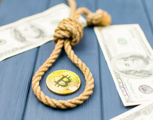 The end of bitcoin. Coin bitcoin in the loop of the gallows and dollars.